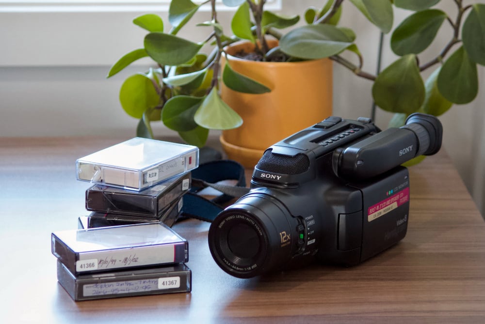 A camcorder sitting next to a pile of tapes
